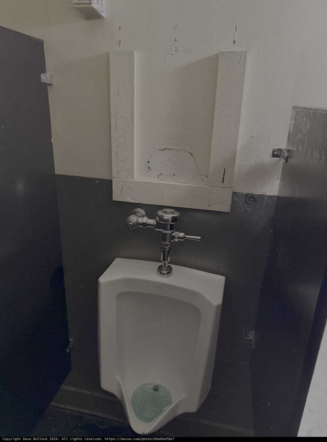 Damaged Bathroom with Vandalized Urinal