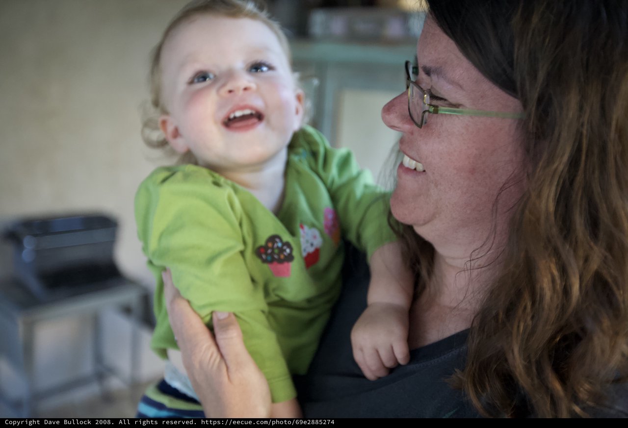 Joyful Toddler Laughing in Mother's Arms