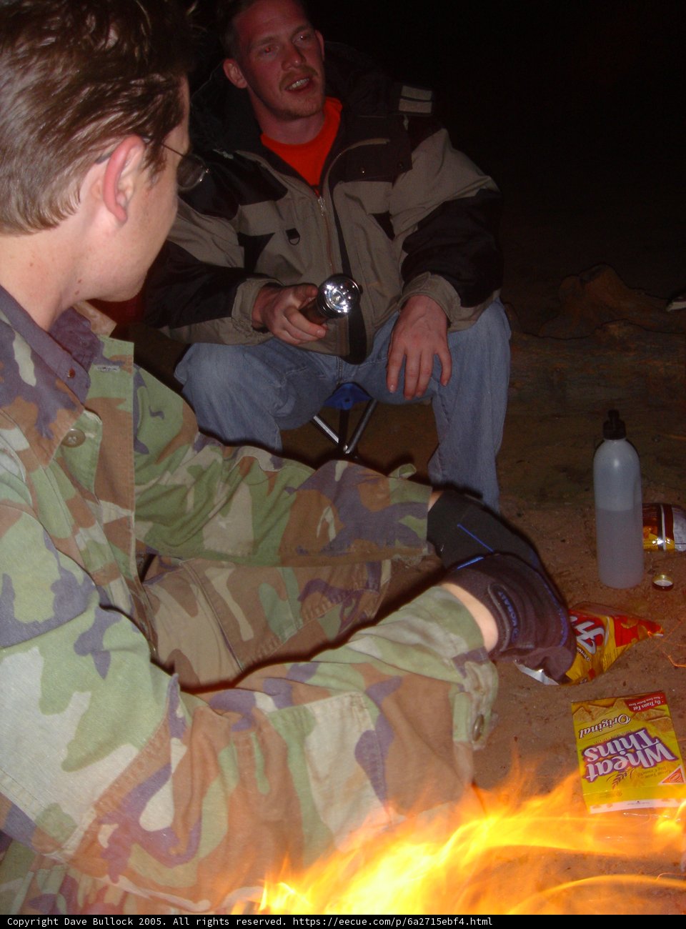 Man Enjoying a Bonfire with a Bottle in Hand