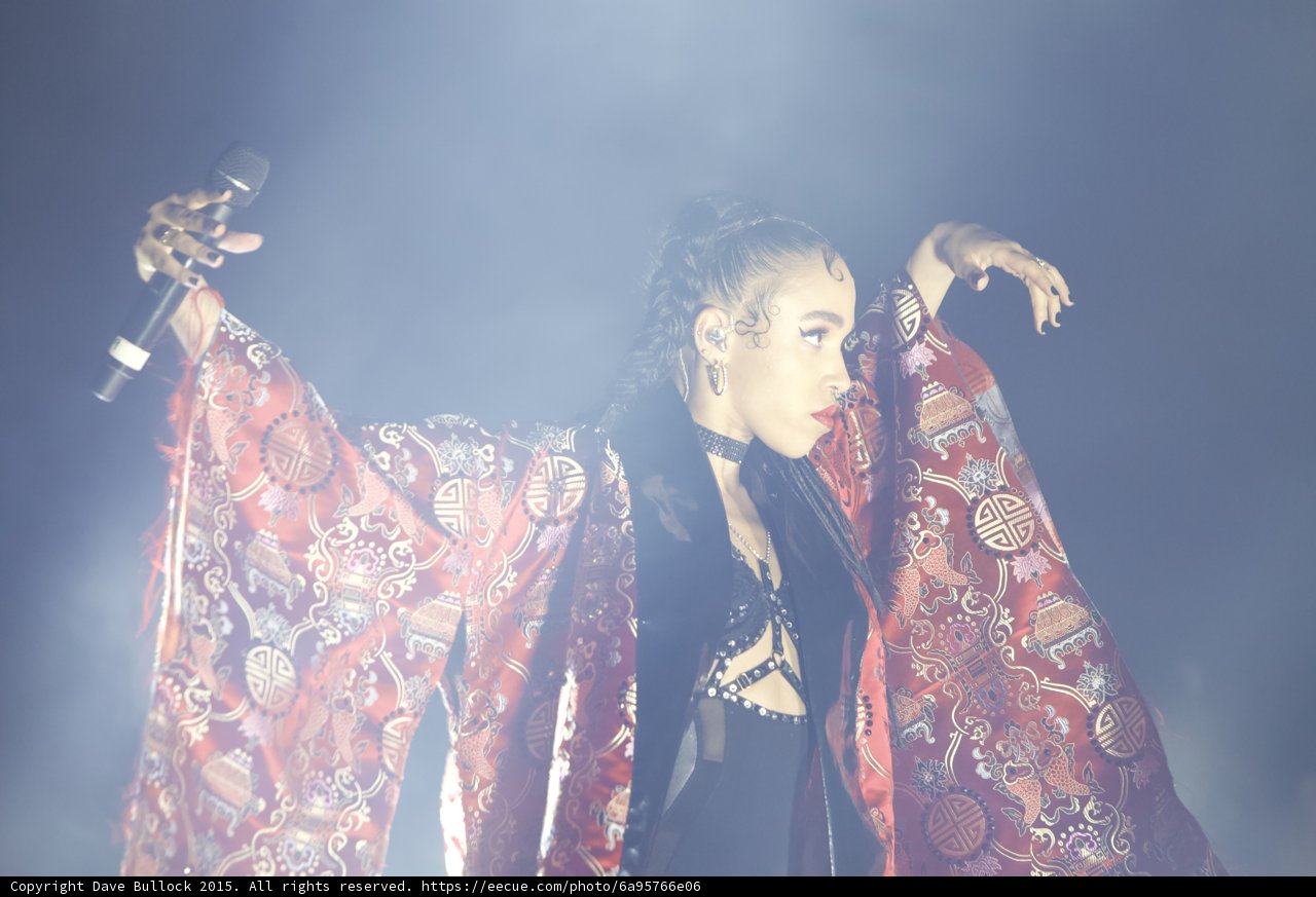 FKA twigs Profile Arms Spread Microphone Red Brocade Kimono Baby Hairs Hoop Earrings Black Choker Necklace