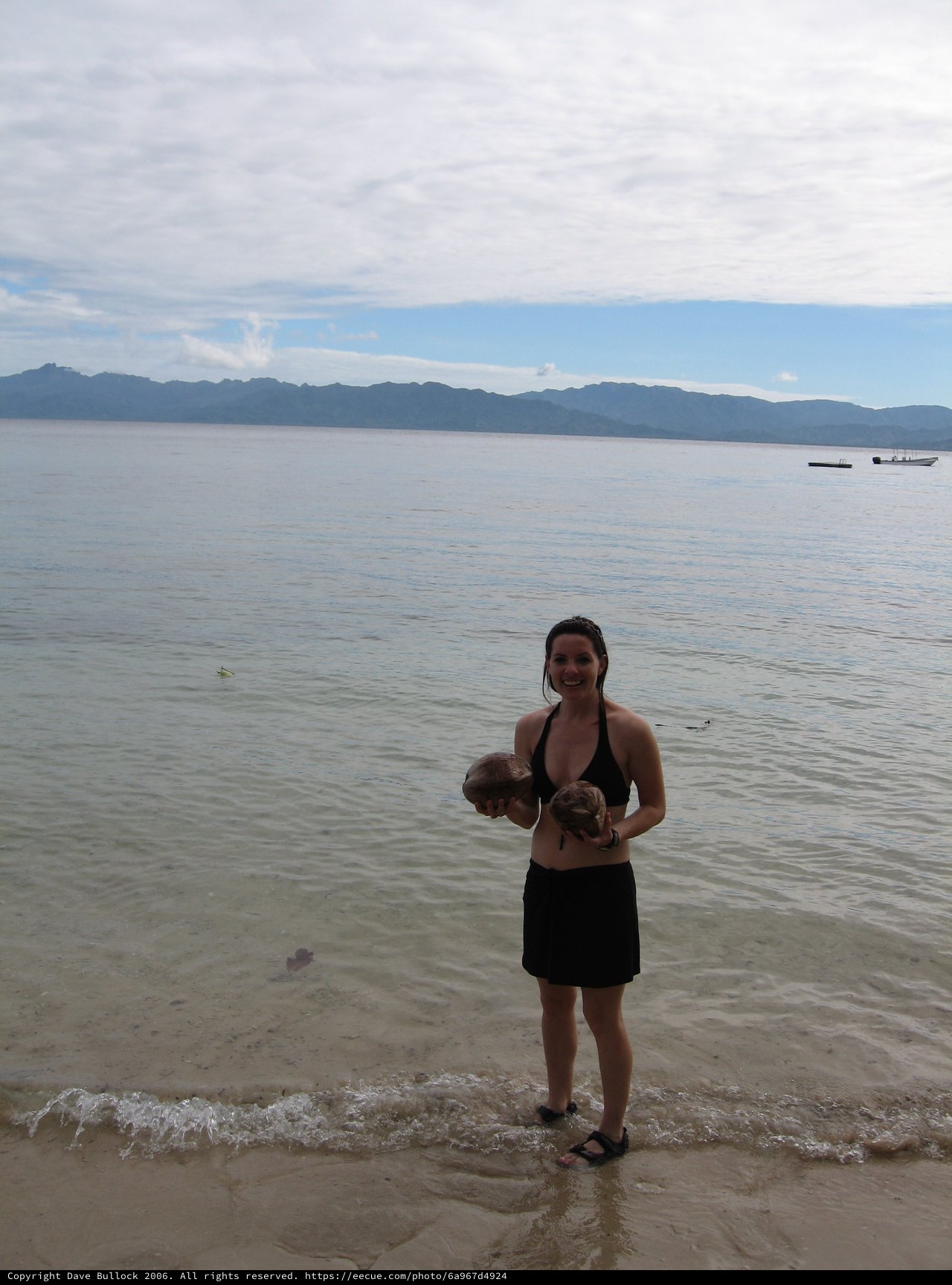 Woman Holding Coconuts on Fijian Beach Shore