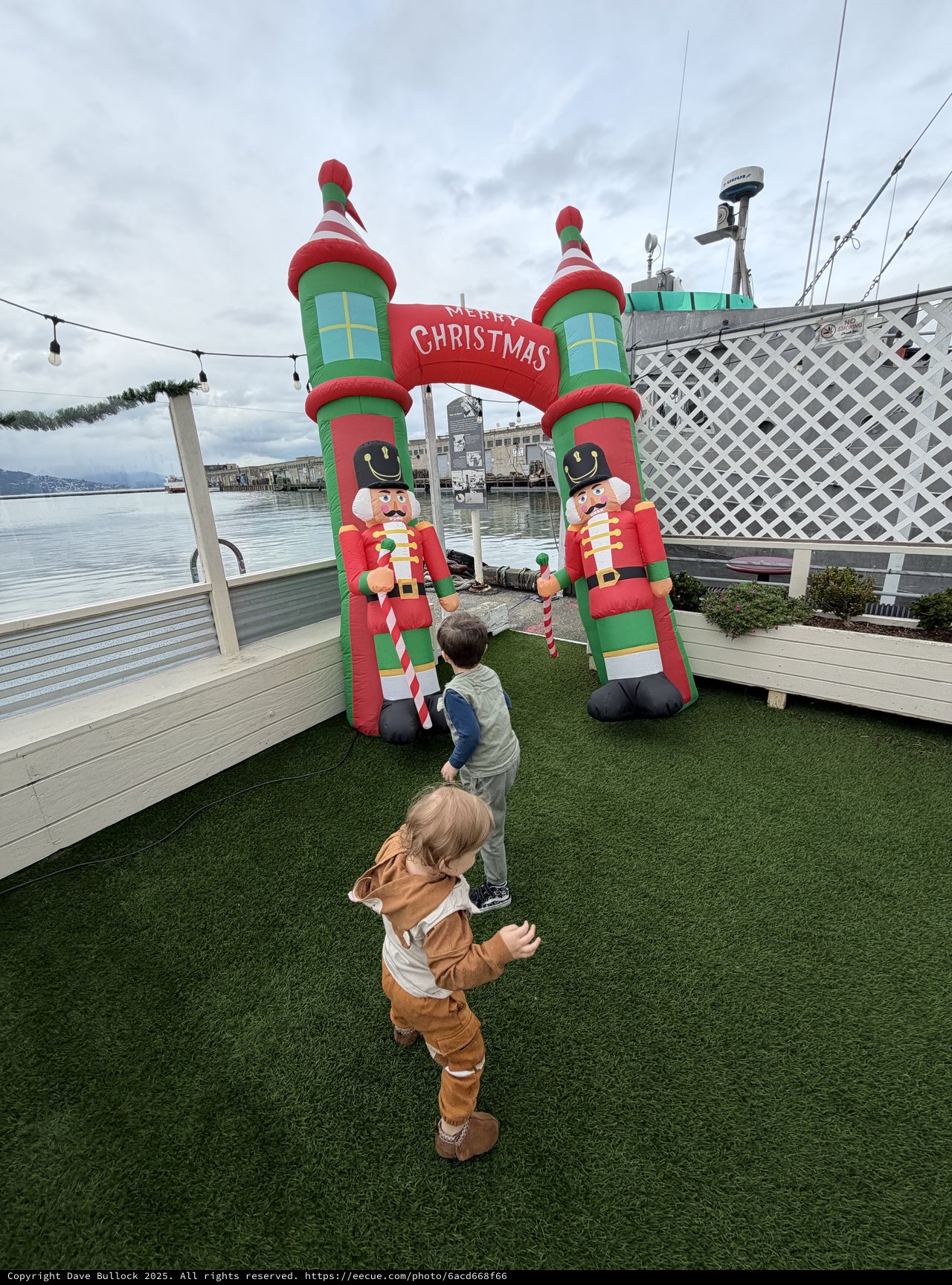 Children Enjoying Inflatable Christmas Display by the Water