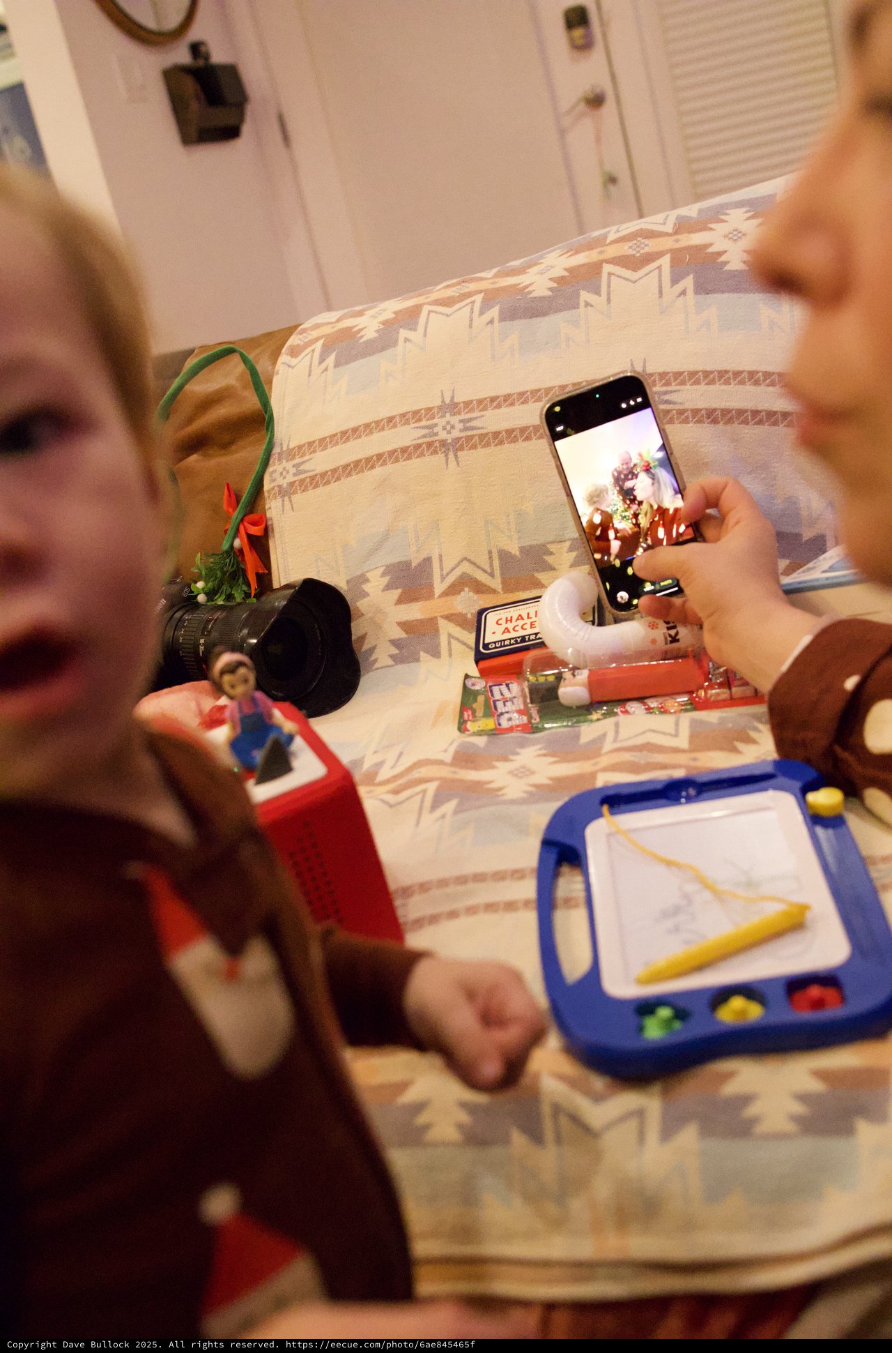 Christmas Day Playtime: Child Capturing Holiday Toys on Phone