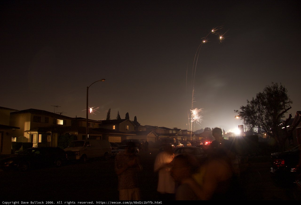 Fireworks lighting up the night sky Caption: A stunning display of fireworks cast a colorful glow over a residential neighborhood on July 4th, 2006.