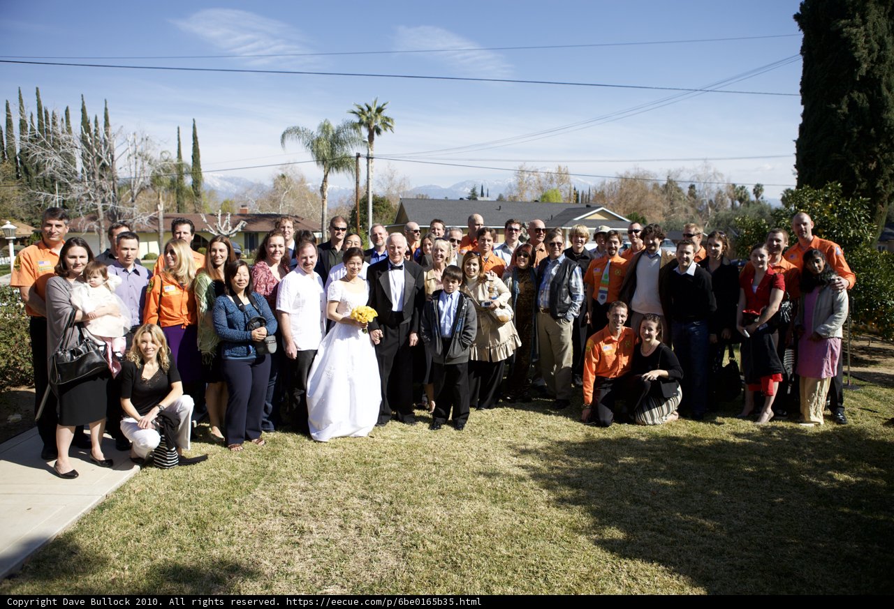A Formal Wedding Party Poses in Front of a Beautiful House
