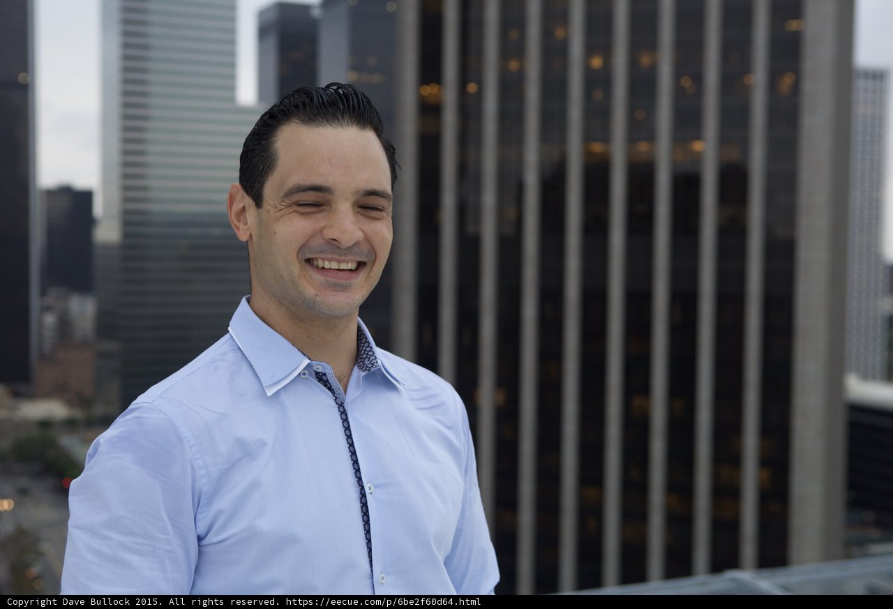 Happy Man in Blue Shirt with City Skyline
