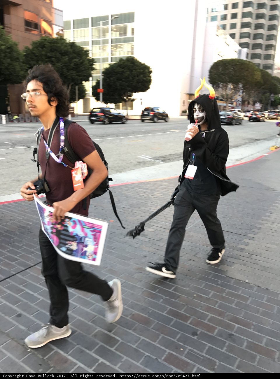Two Men Walking Down a Street with a Skateboard