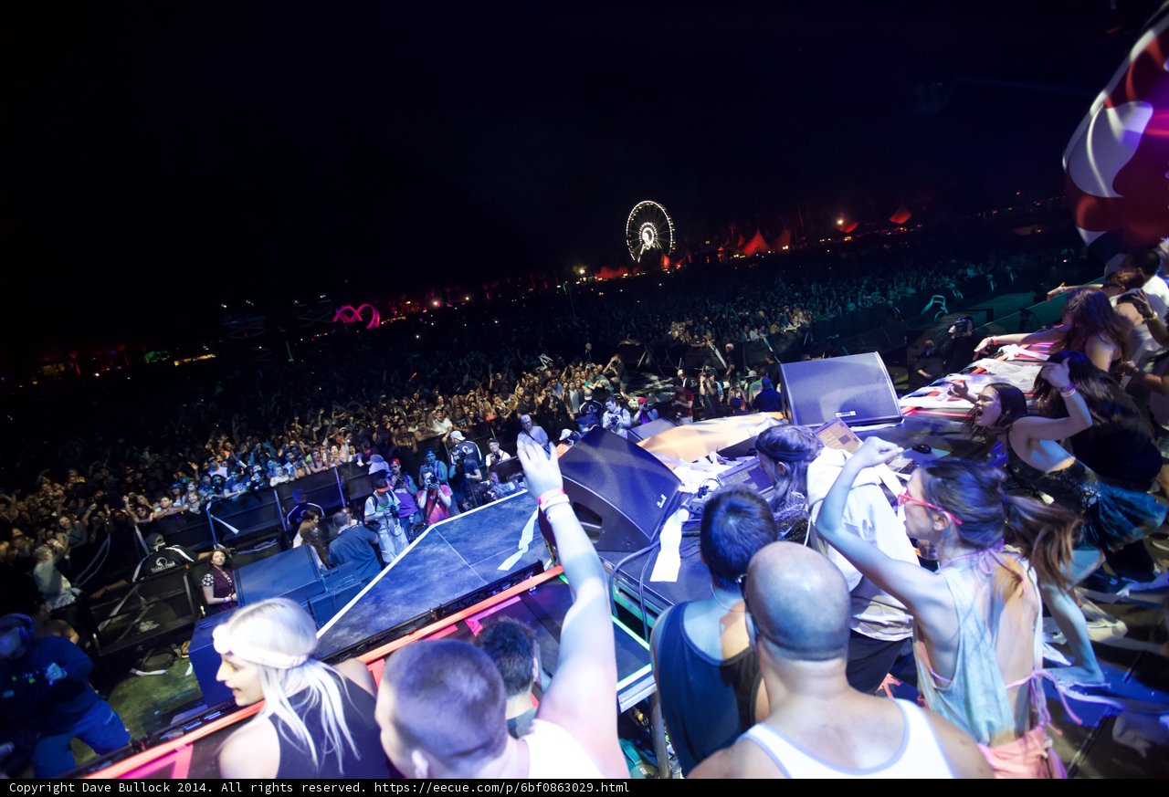 Concert-goers enjoy the Ferris wheel in the background