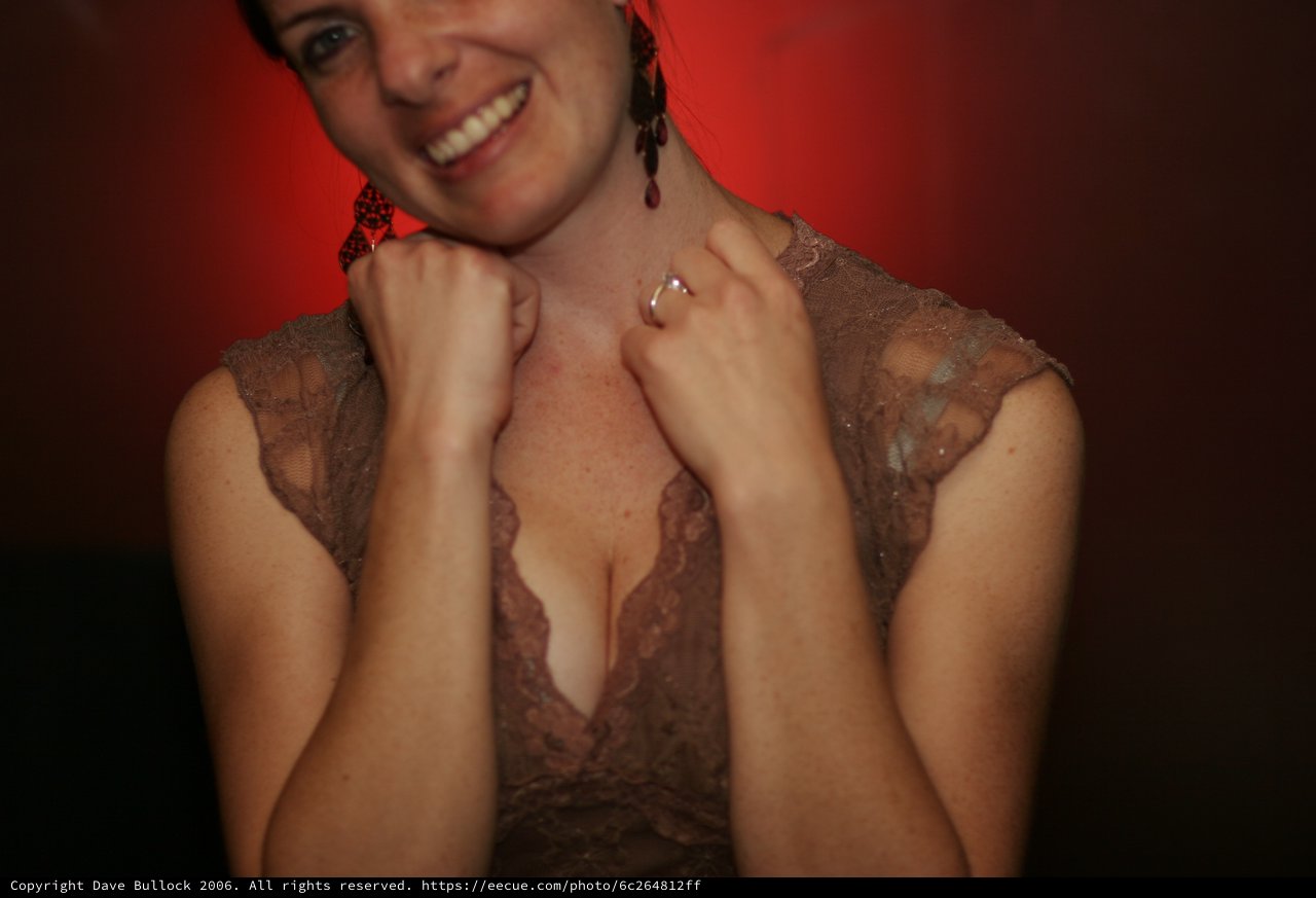 Smiling Woman in Lace Dress Against Red Background