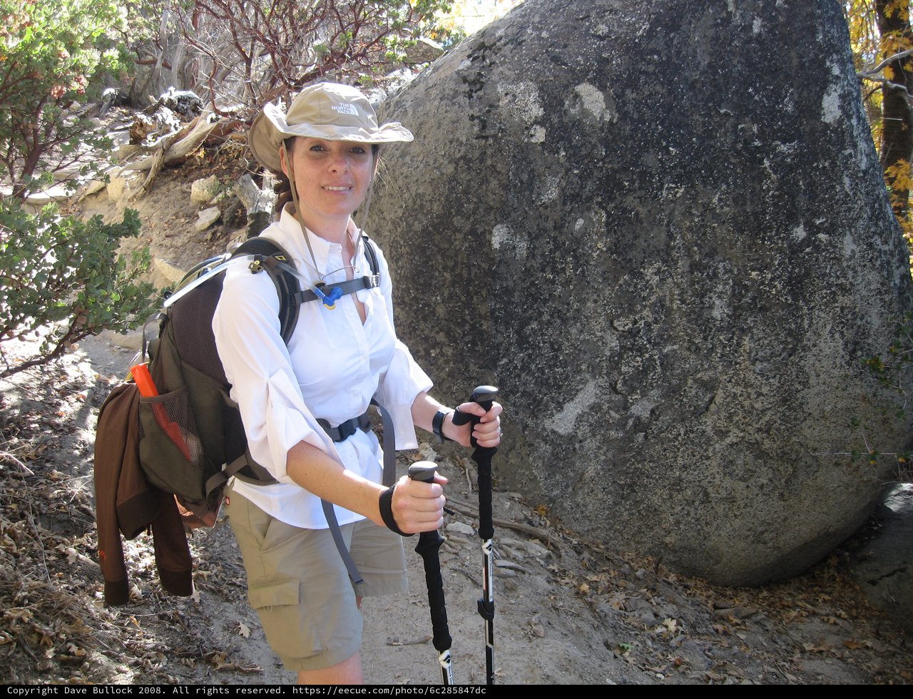 Hiker Pauses Beside Granite Boulder on Mountain Trail