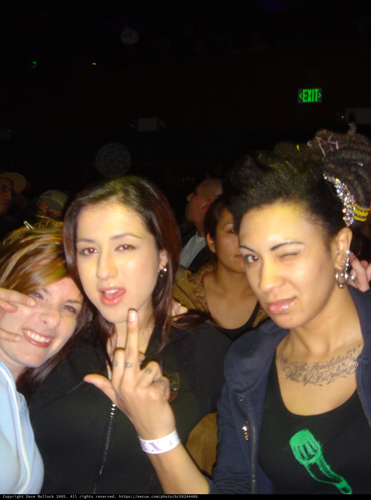 Three Friends Posing at a Dark Concert Venue