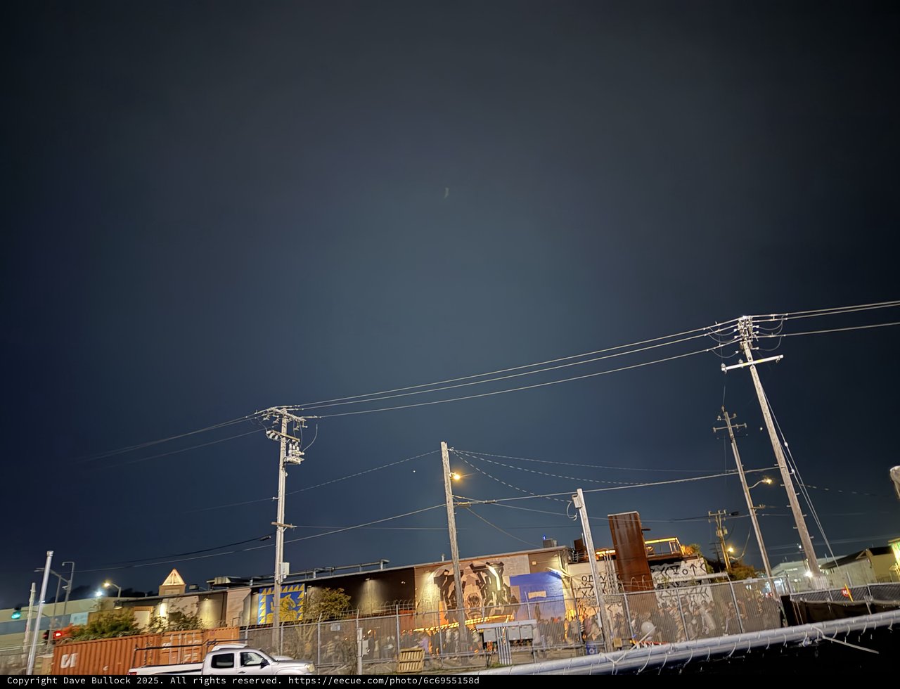 Urban Night Scene with Power Lines and Industrial Buildings