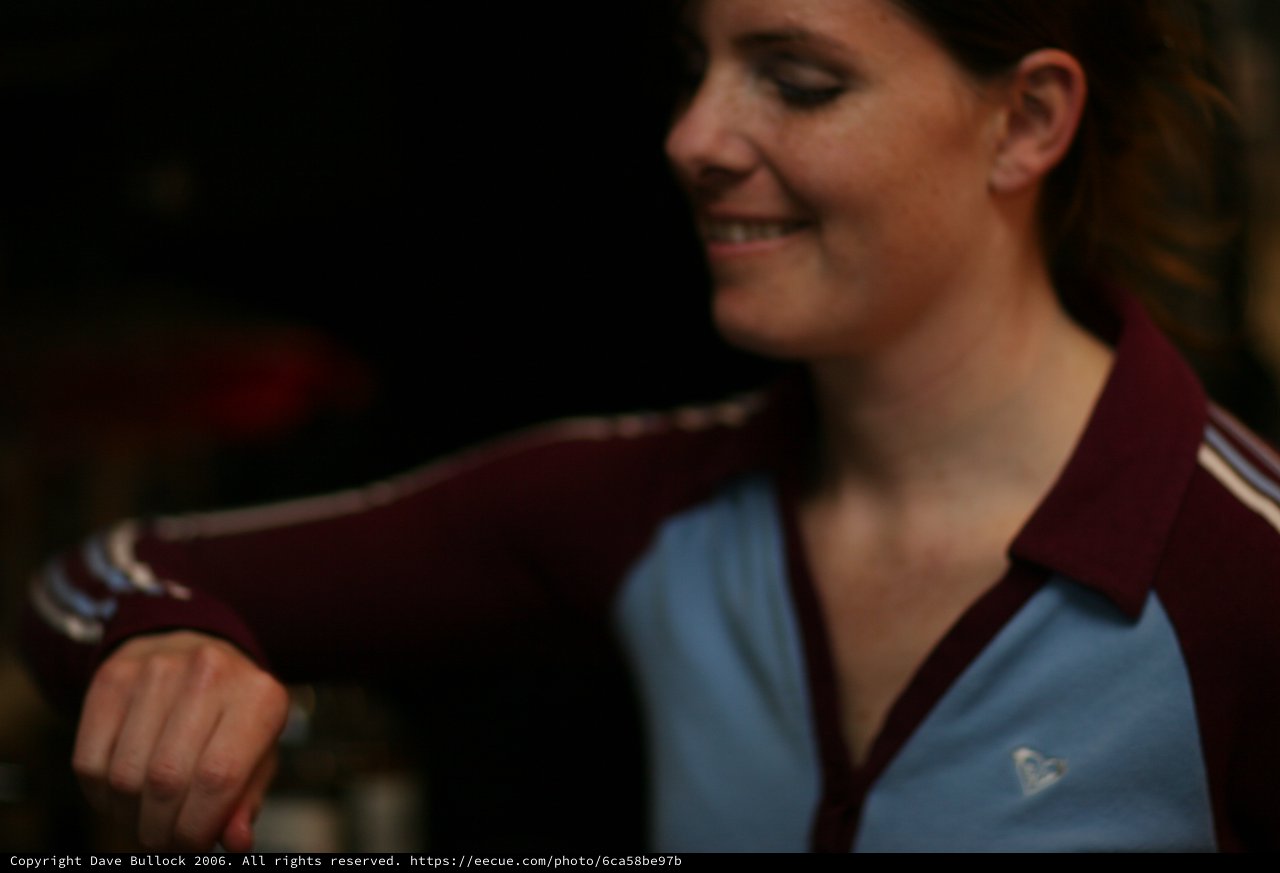 Woman in Retro Track Jacket Smiling Downward