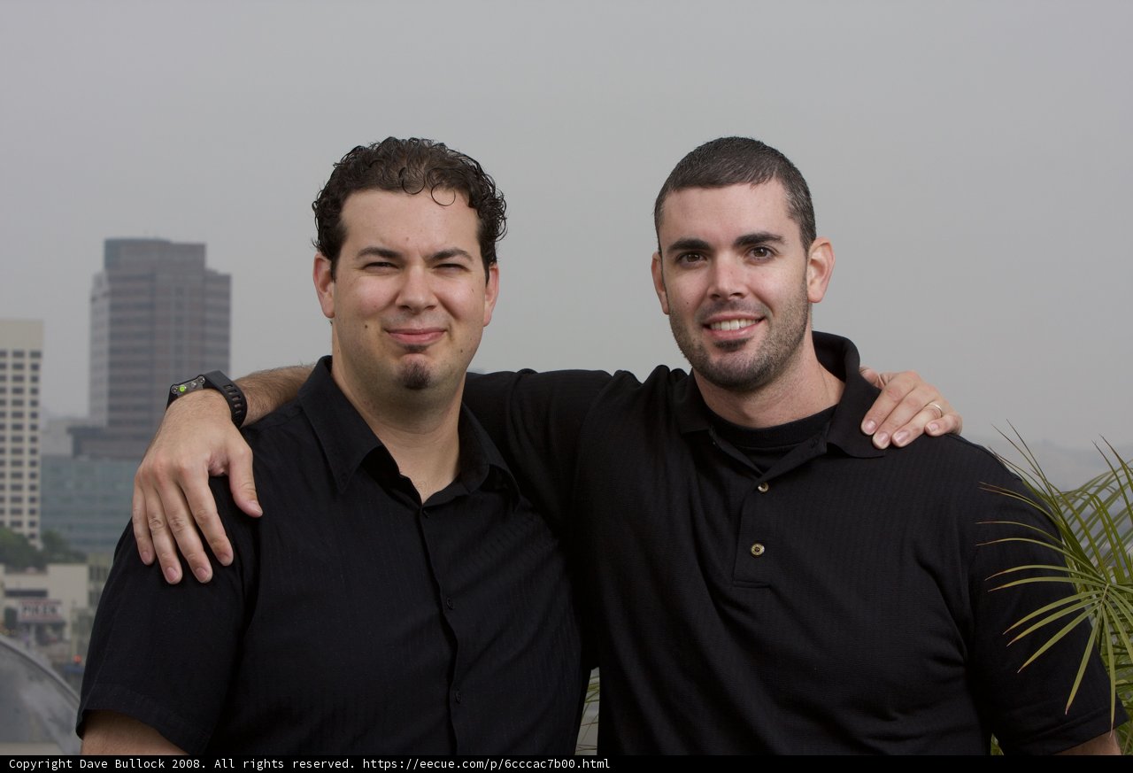 Two Happy Men Posing in Front of a Skyscraper