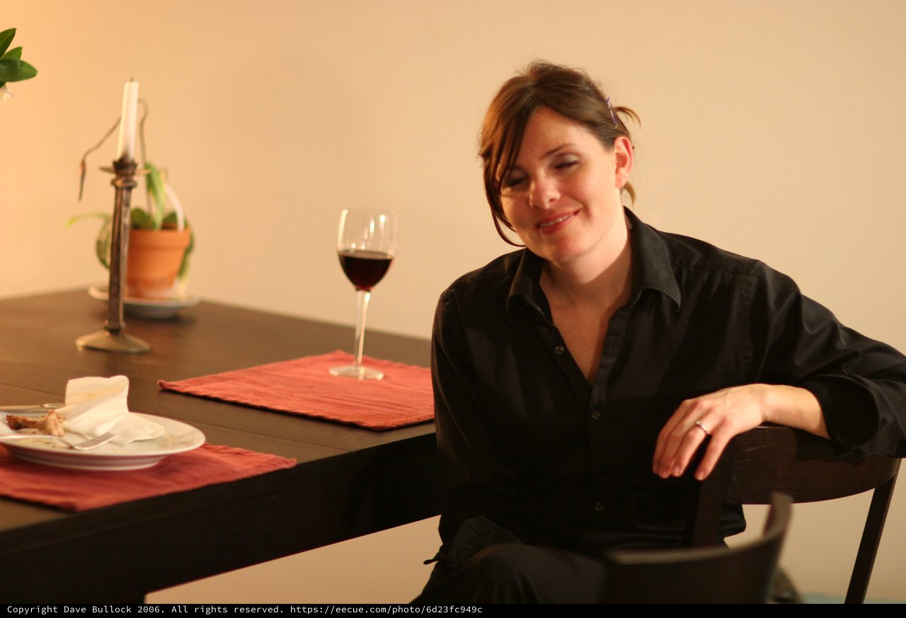 Woman Smiling at Dinner Table with Red Wine
