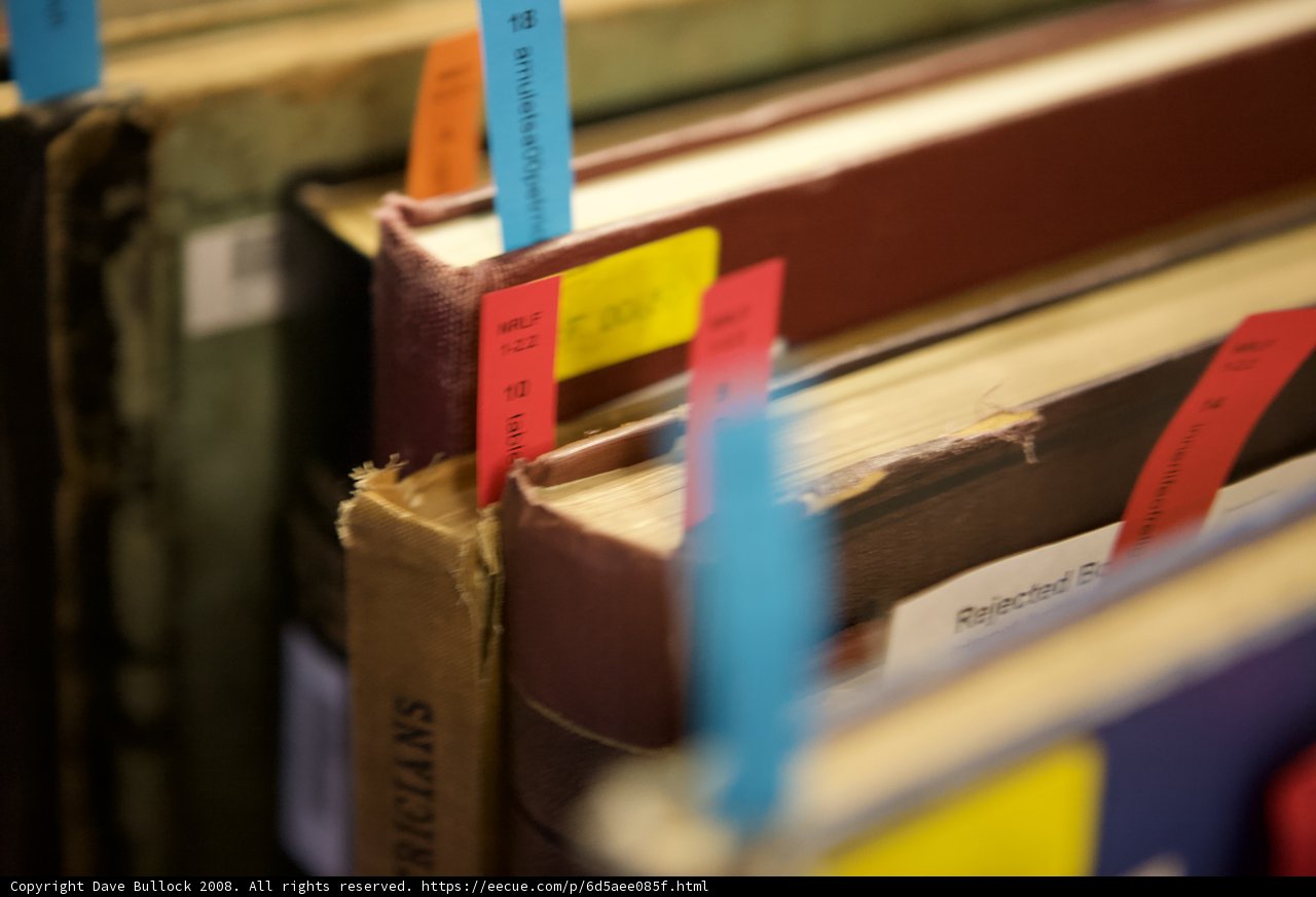 Colored Sticky Notes on a Row of Books