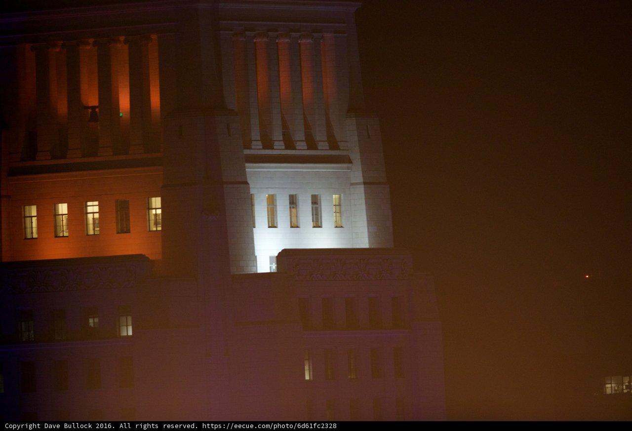 Glowing Clock Tower in Urban Landscape