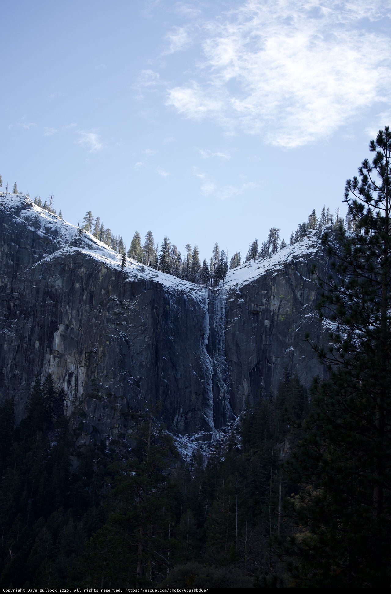 Snowy Waterfall Cascading Down Dark Granite Cliffs