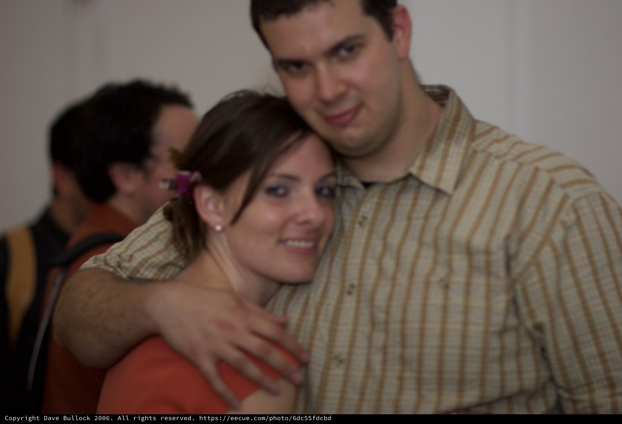 Couple Embracing Warmly at an Indoor Gathering