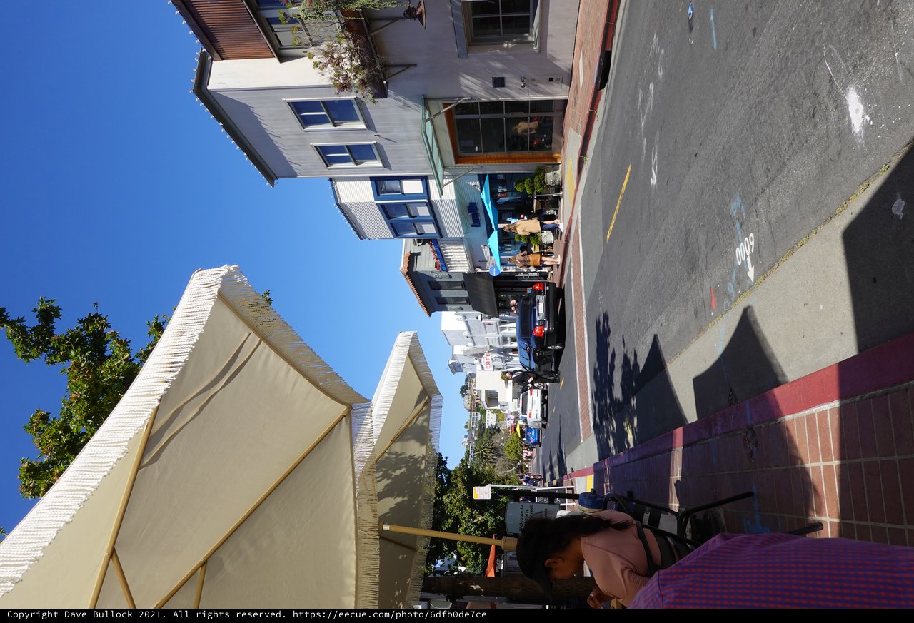 Sunny Coastal Town Street Scene with Umbrella