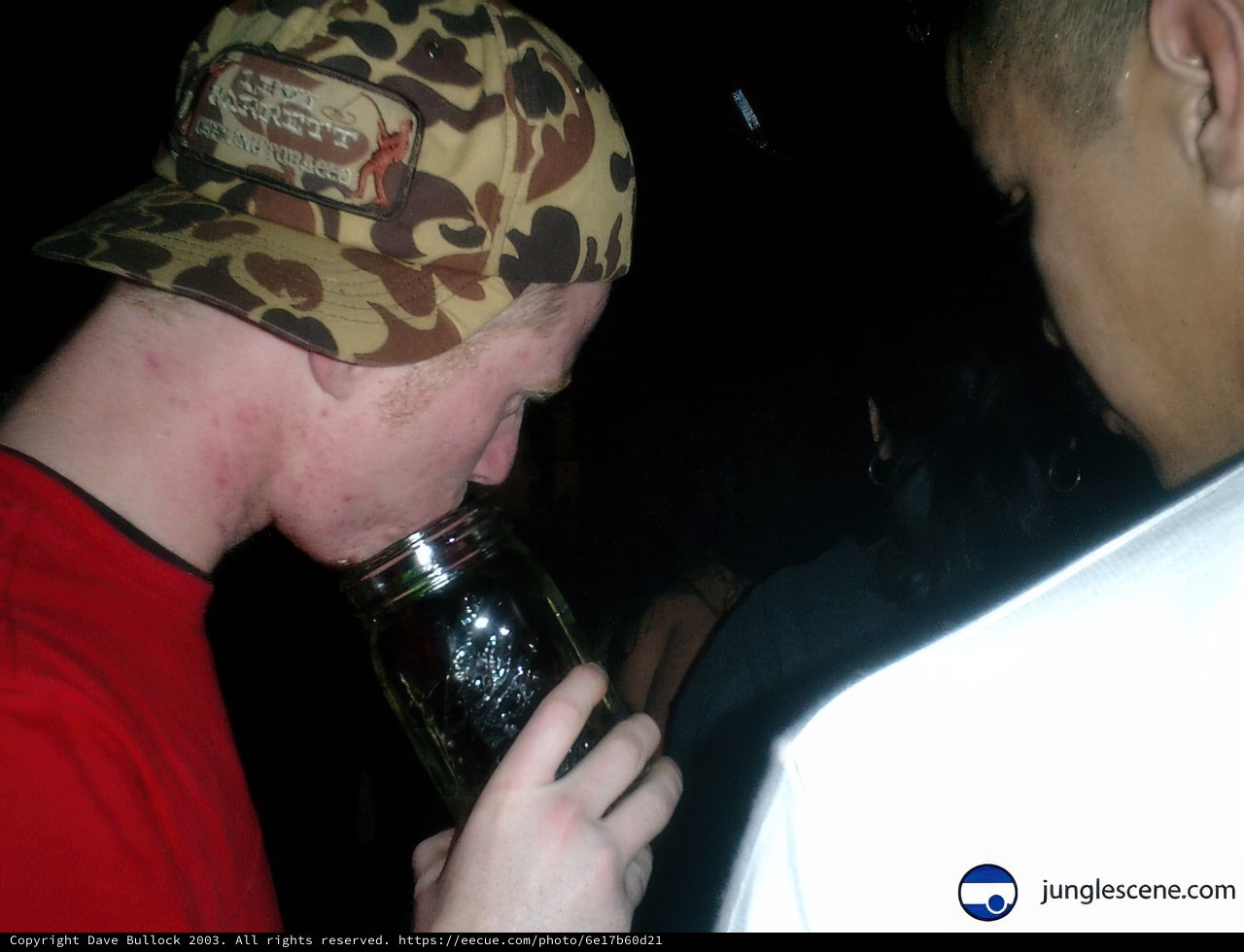 Man Drinking From a Jar of Beer