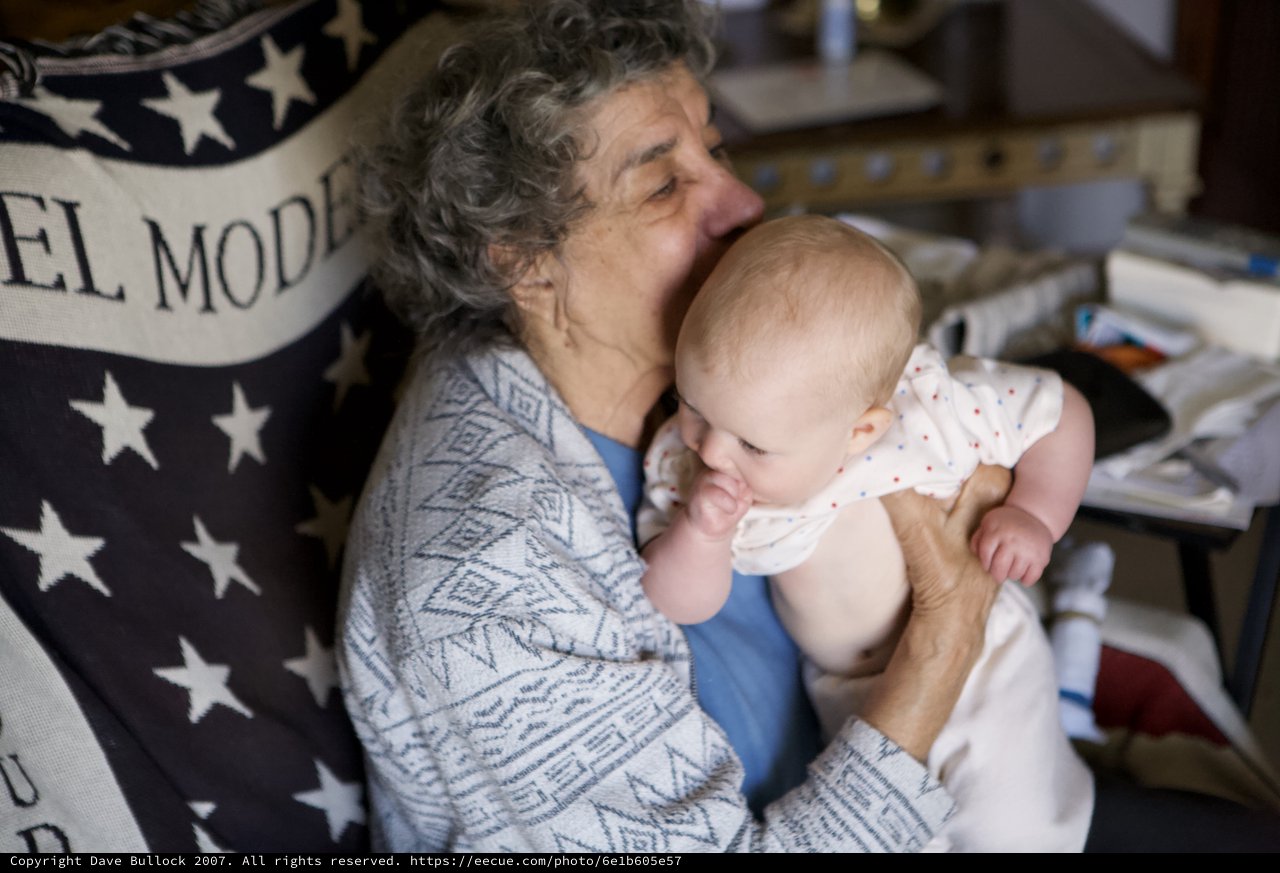 Grandmother's Tender Kiss with Precious Newborn Baby