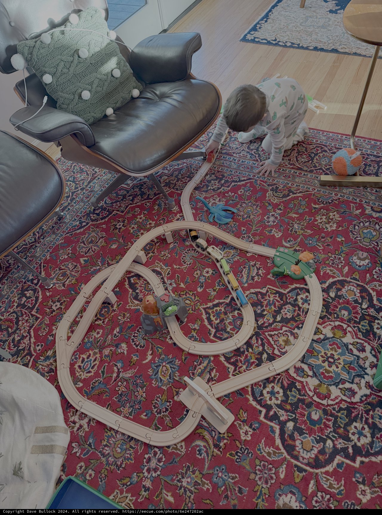 Child Playing with Wooden Train Set at Home
