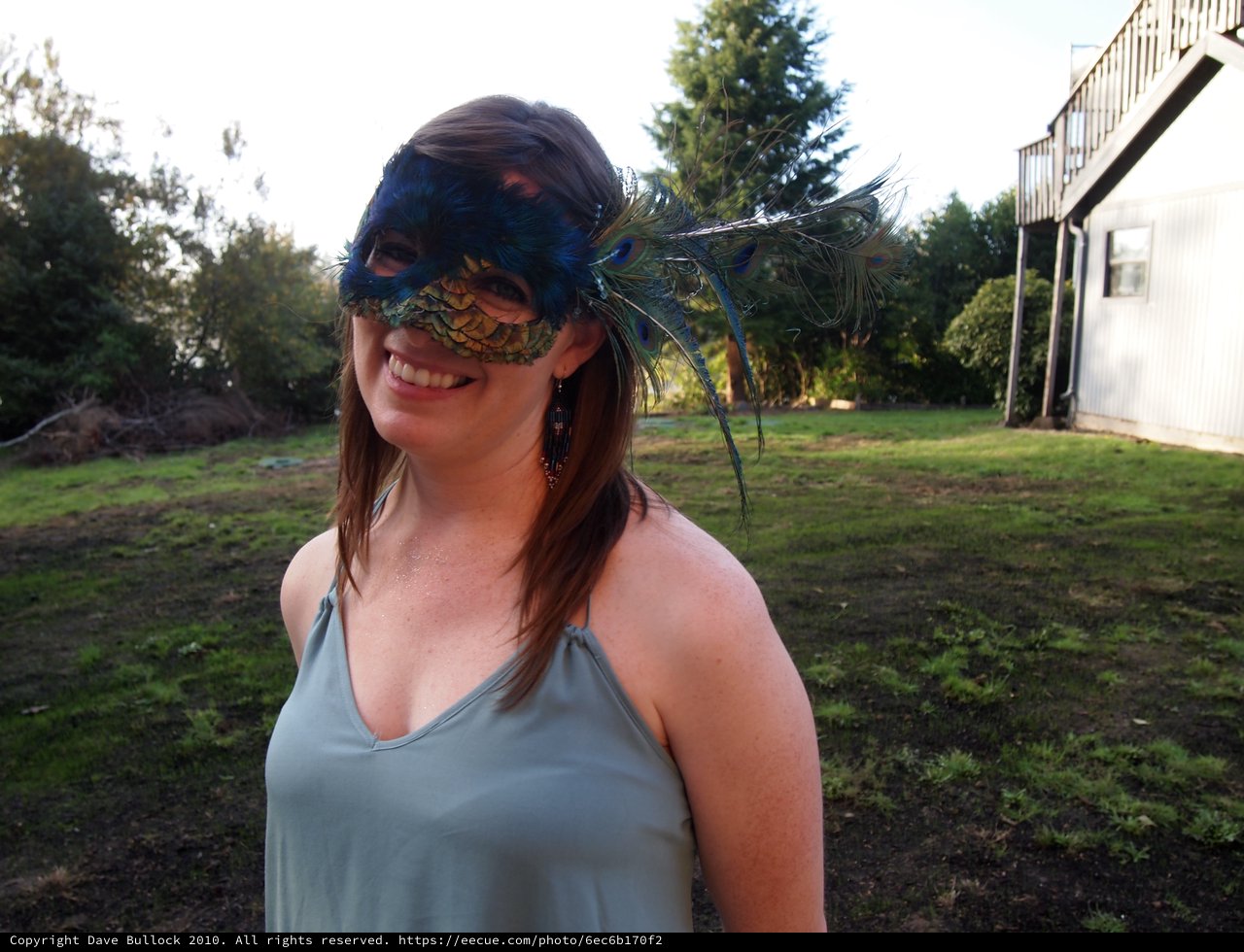 Smiling Woman in Peacock Feather Masquerade Mask