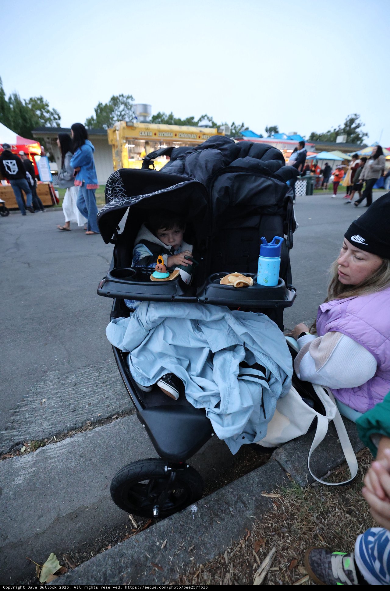 Tired Toddler in Stroller at Outdoor Festival