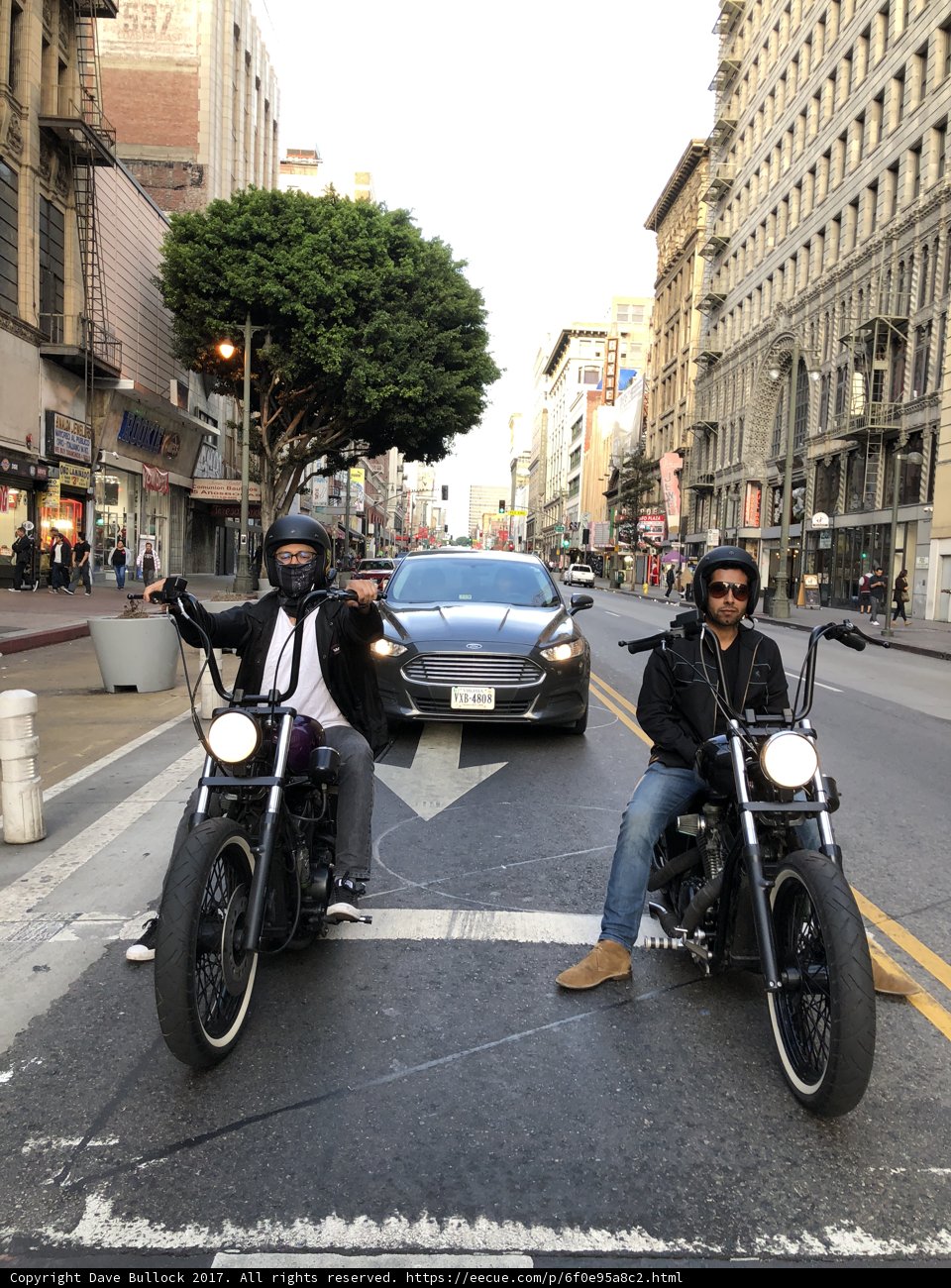 Two Men Riding Motorcycles through the City