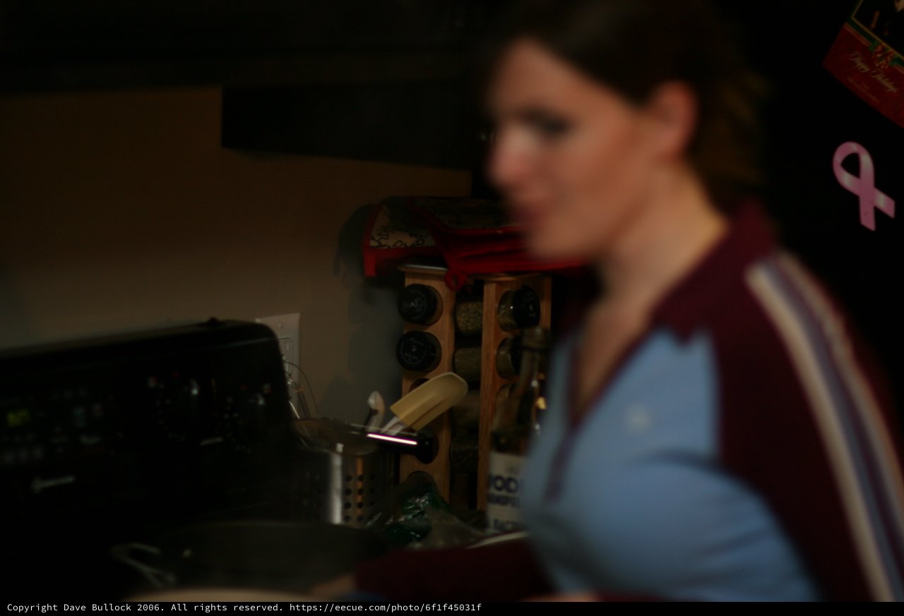 Woman in Kitchen Amid Organized Chaos at Night