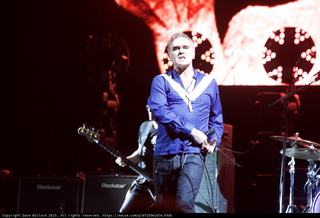Morrissey Singing Blue Shirt Bassist Behind Blackstar Amps Circular Lights Red Video Screen Stage