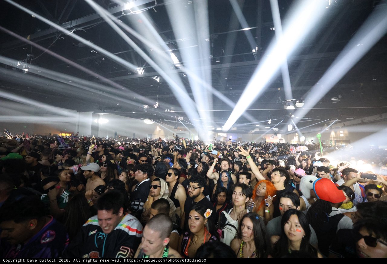 Massive Indoor Rave Crowd Bathed in Spectacular Light Beams