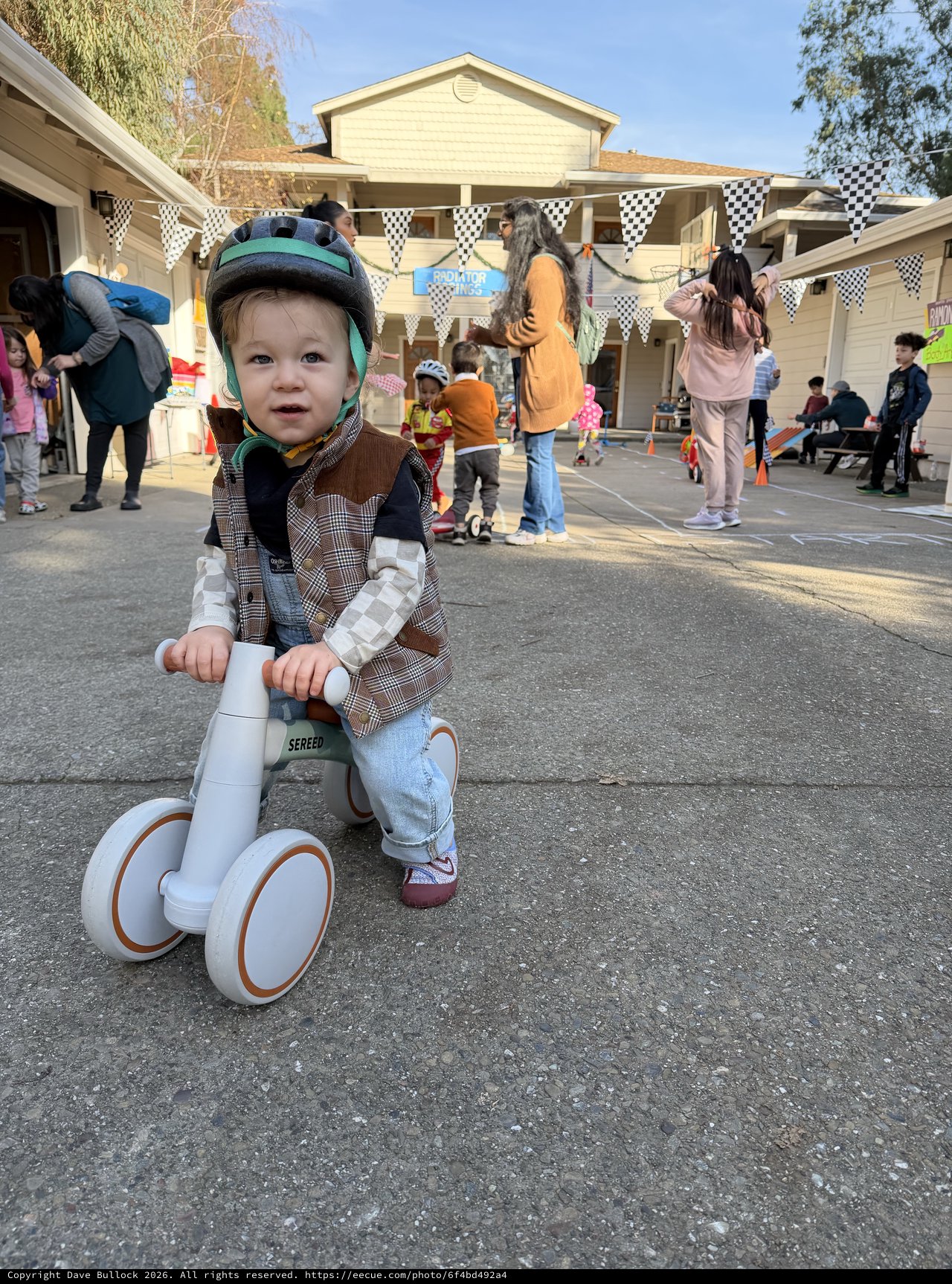 Young Child on Balance Bike at Neighborhood Block Party