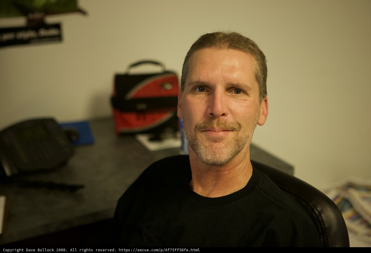 Smiling man with a black shirt and mustache