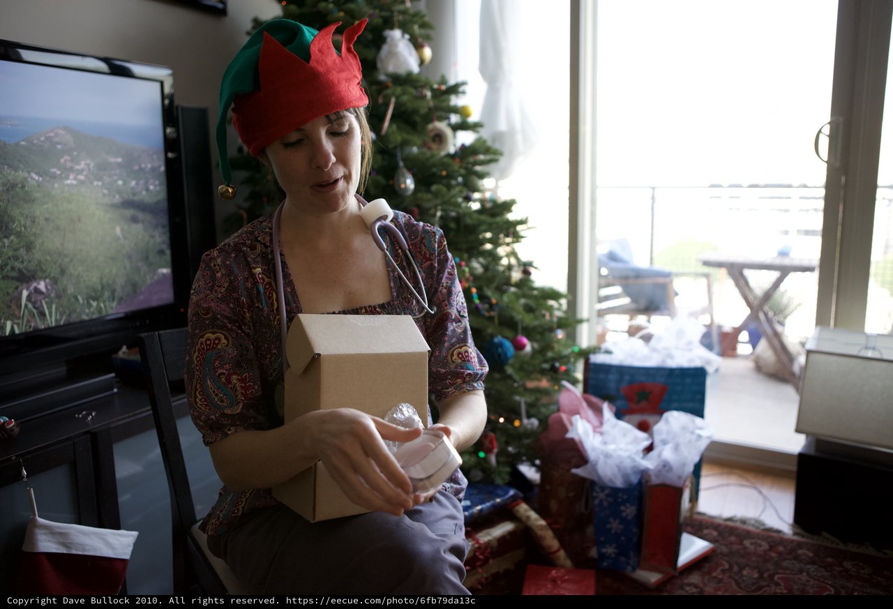 Festive Elf Unwrapping Christmas Gifts at Home