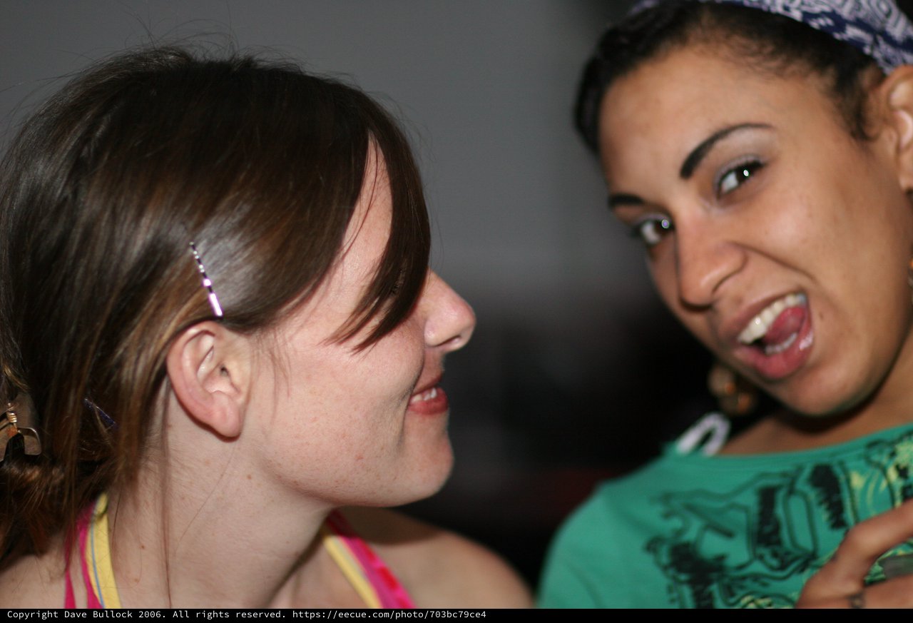 Two Friends Laughing Together at a Social Gathering