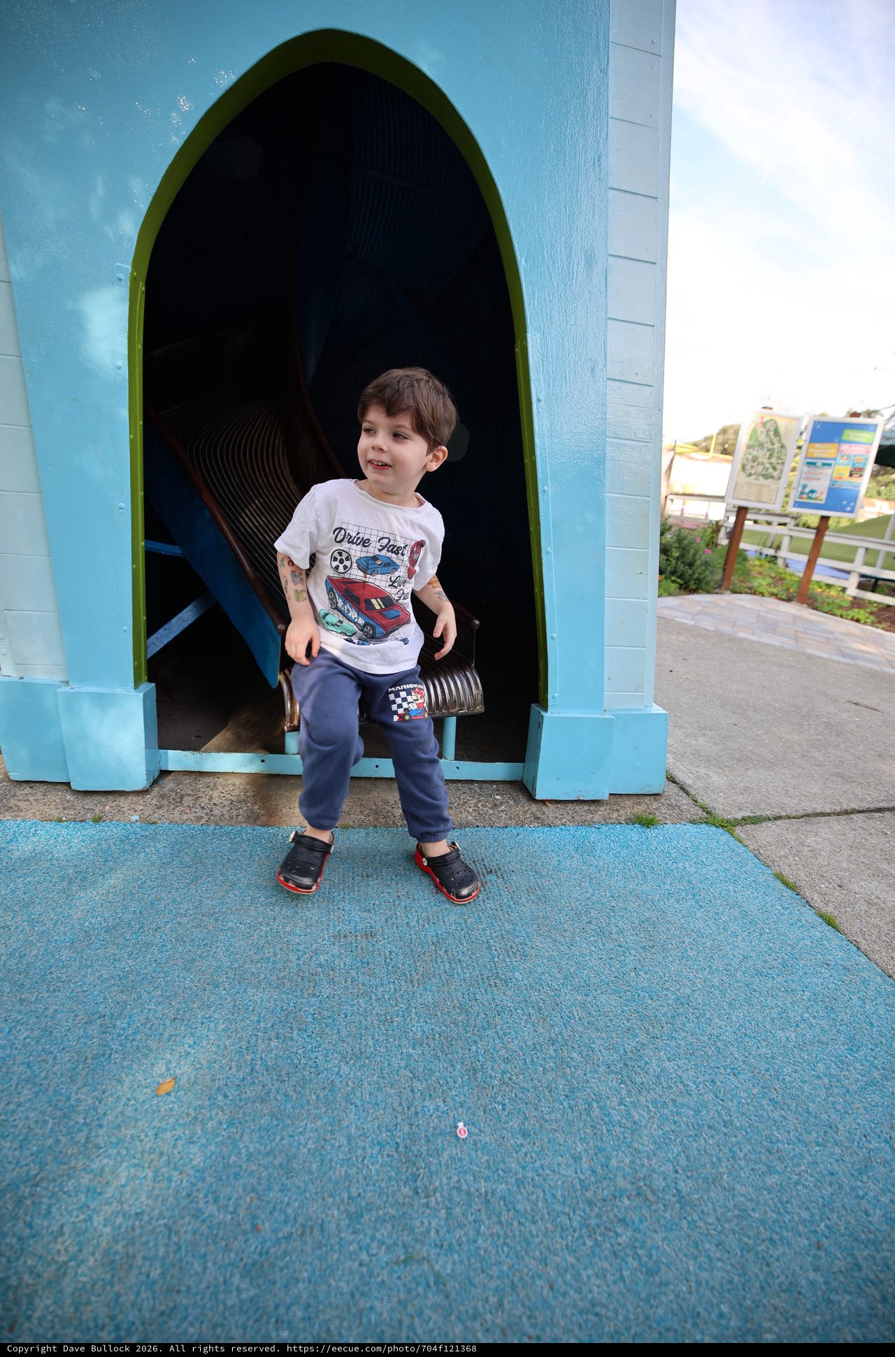 Young Boy at Colorful Playground Tunnel Entrance