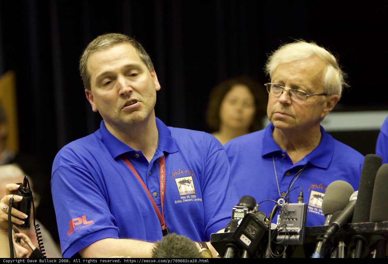 Press Conference with Two Men in Blue Shirts