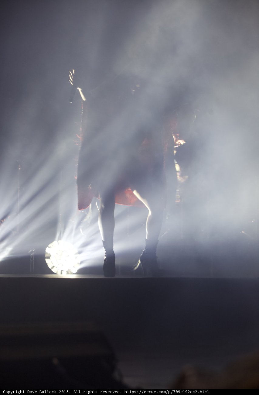 FKA twigs Silhouette Wide Shot Arms Raised Light Beams Haze Red Kimono Floor Light Band