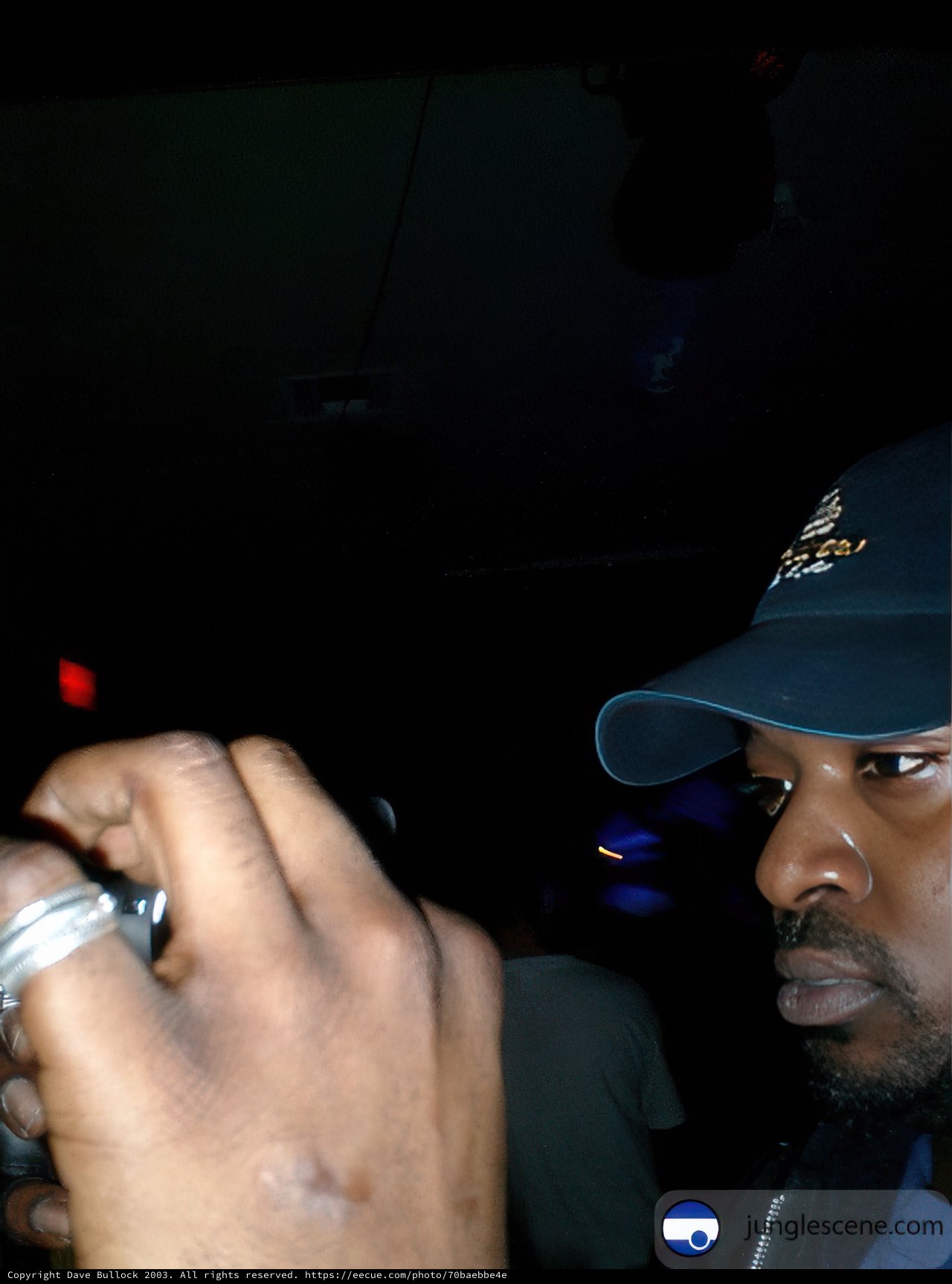 Man in a Blue Cap Checking the Time on his Cell Phone