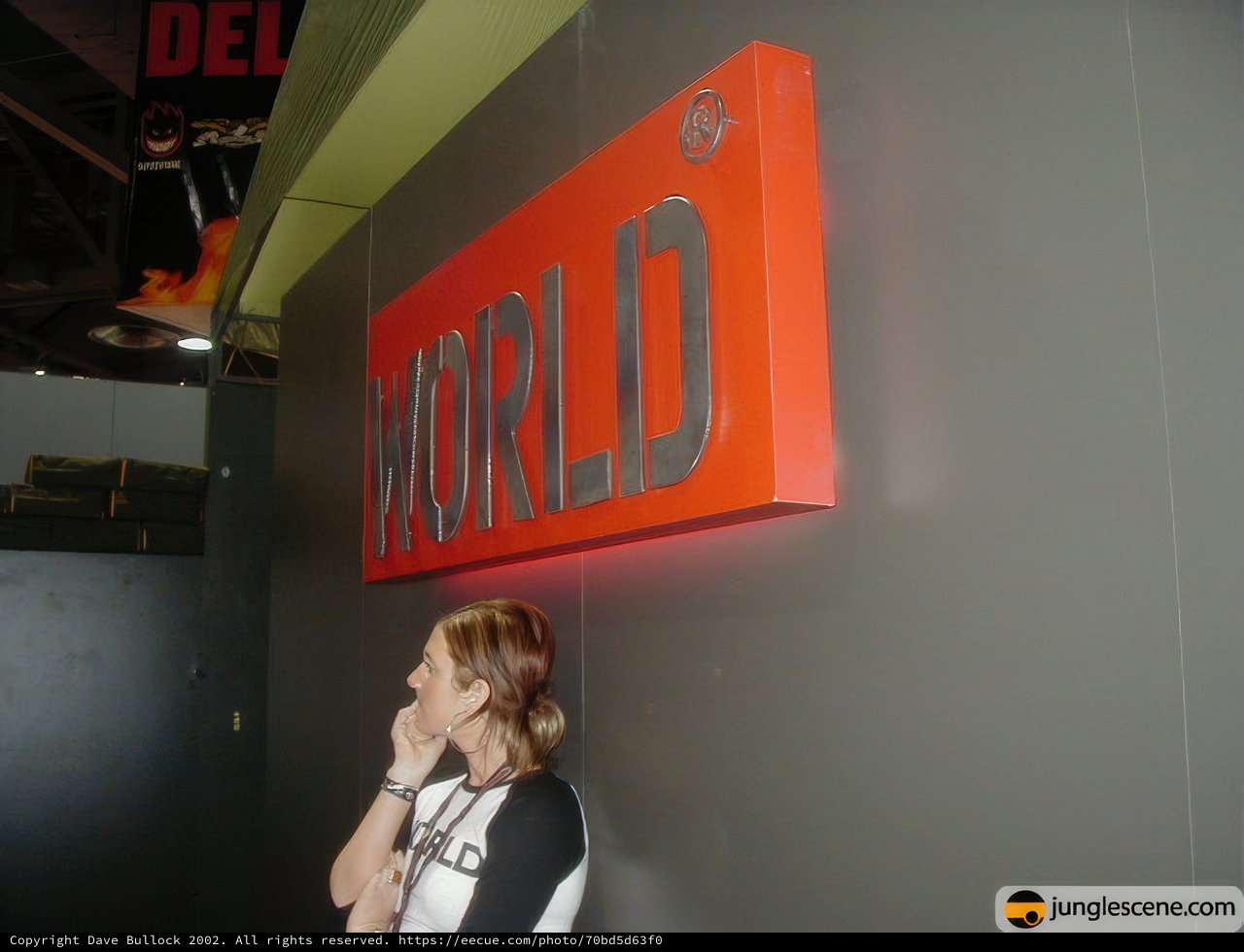 Woman Standing in Front of "World" Sign