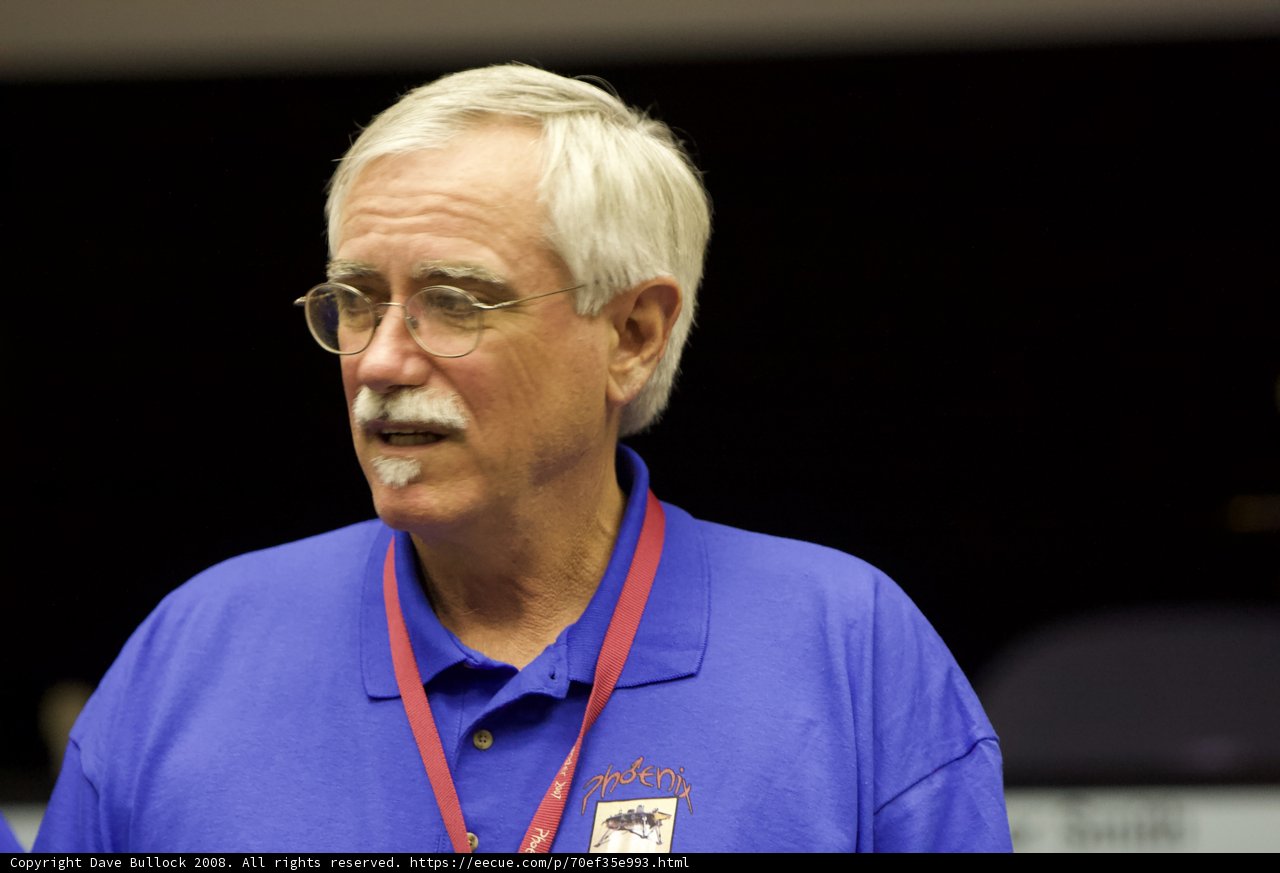 The Blue-Shirted Man with White Hair and Mustache