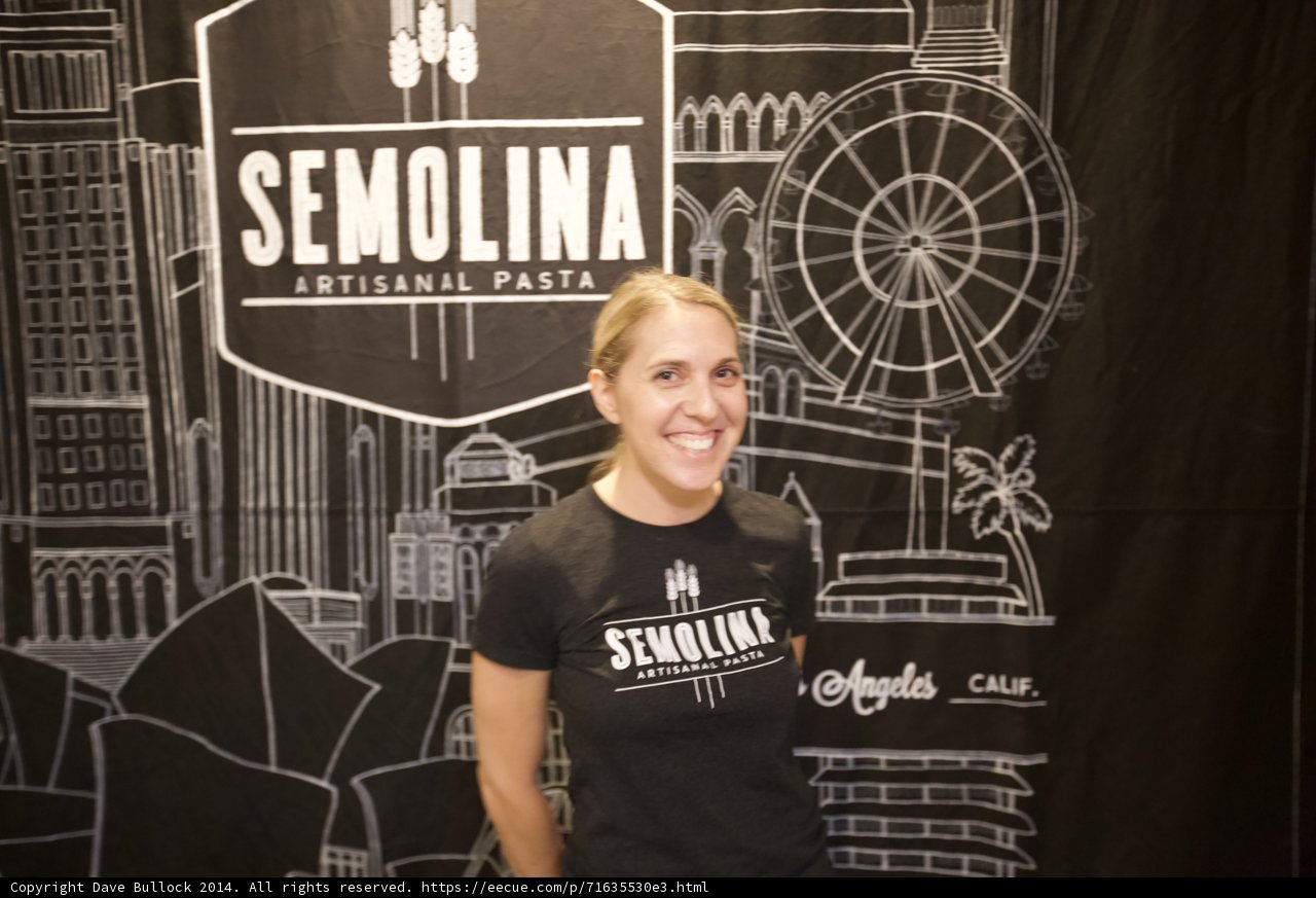 Smiling Woman Poses in Front of Semolina Sign