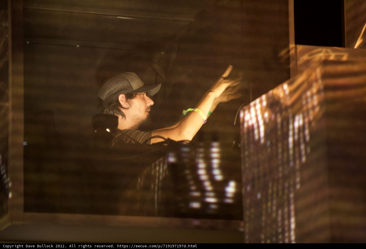Man in Hat Stands Before Large Screen