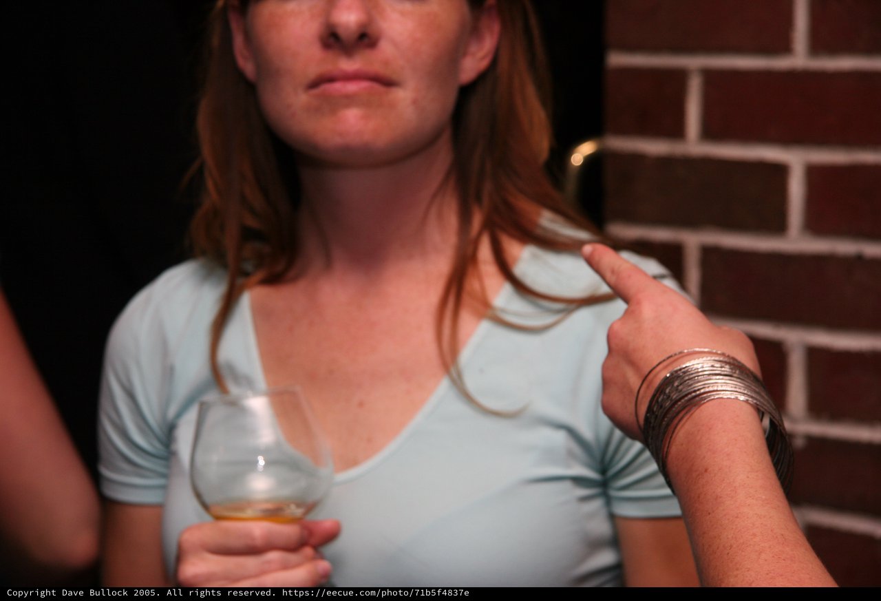 Woman Holding Whiskey Glass at Brick Wall Bar