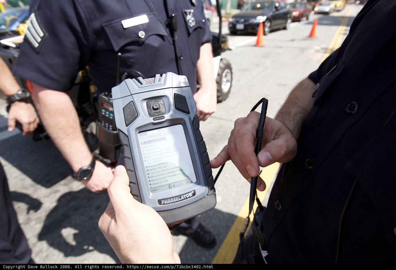 Police Officer with Handheld Device at Mayday Rally
