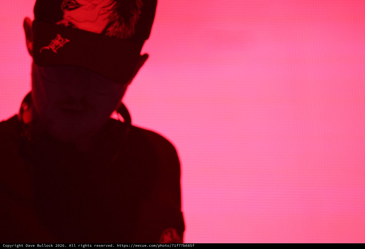 Masked Performer Bathed in Crimson Stage Light
