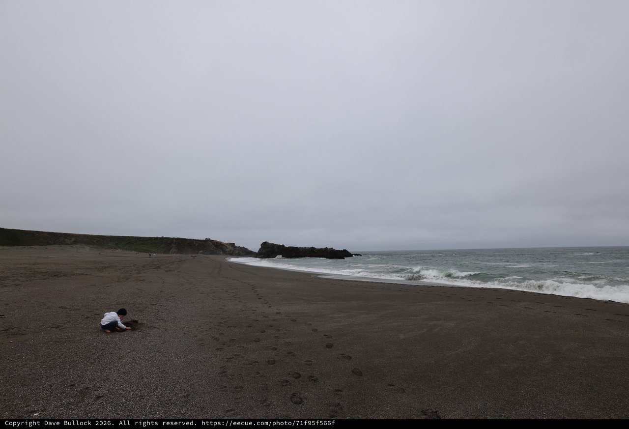 Child Playing Alone on a Moody Coastal Beach