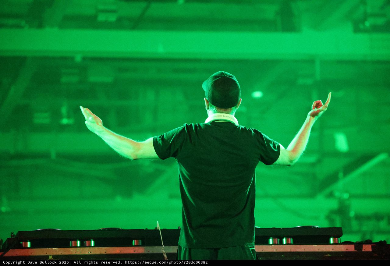 DJ Commands the Crowd Under Electric Green Lights